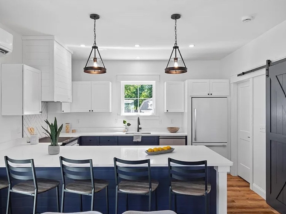 Kitchen with navy lower cabinets and pendant lighting